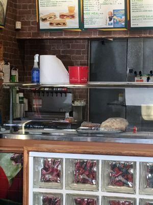 Sanitation and cleaning materials above a prep board with food out.   Poison anyone yet?