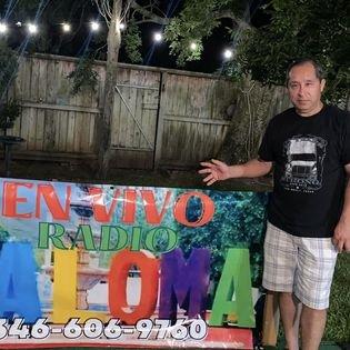 Compa Toño Cruz posando junto a la banderola de Radio La Loma