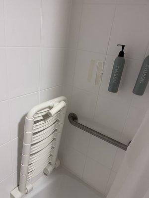 Missing shampoo bottle that seemed to be ripped off along with a seat for the shower