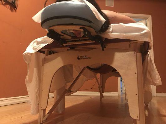 Specialized prenatal table has a cut out with an adjustable net that allows you to lay face down .