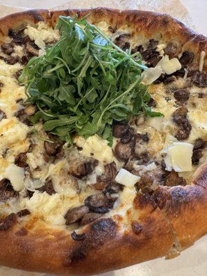 Truffle mushroom pizza with mozzarella, ricotta, and arugula. On Special now.