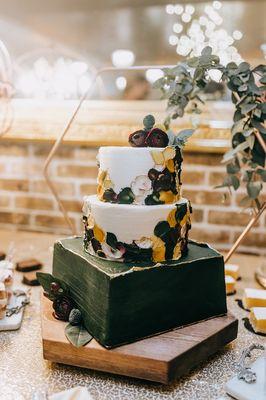 3 tiered wedding cake in jewel tones with palette flowers.