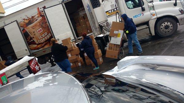 This is two cigarette smoking employees at the 50 Clinton Street Dunkin Donuts, unloading food boxes onto the wet muddy dirty ground. Yuck!