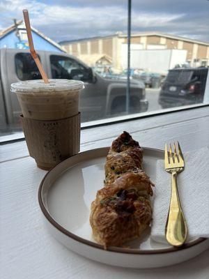 Iced americano with caramel and cream, savory breakfast pastry with bacon.