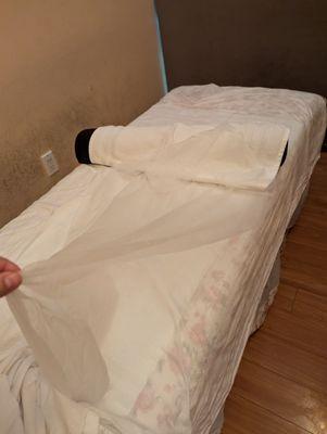 Thin sheet over bed.