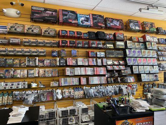 This wall features many old school consoles and peripherals for sale.