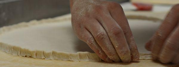 Fresh pizza dough made daily never frozen. Crimping the edge of the pizza crust is our specialty!