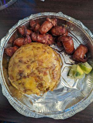 Mofongo with ripe plantains and chicharron mixed together and side of sausage.