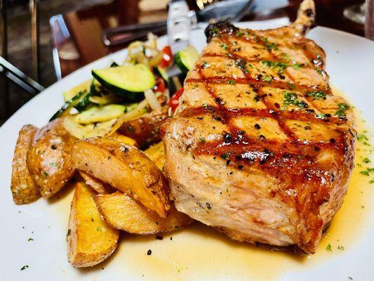 Pork chop with veggies, and potatoes.