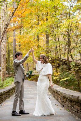 Joyful bride and groom dancing under the autumn trees at Anthony Chapel, Hot Springs. Photo: Michele McCoy Photography