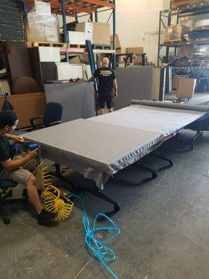 Putting new fabric on cubicle panels.