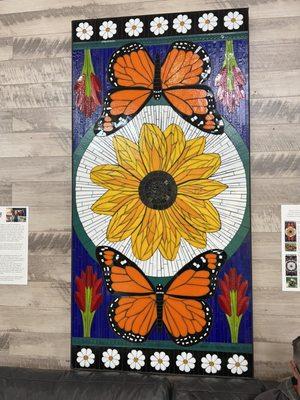 Mosaic by local artist with a detailed story on a wall plaque