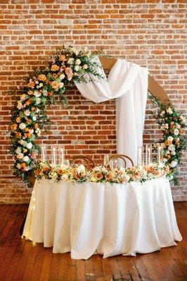 Repurposed arch and bridesmaid bouquets for a romantic sweethearts table!