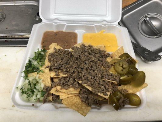 Delicous NACHOS, tortilla chips with homemade asada (steak) all the way