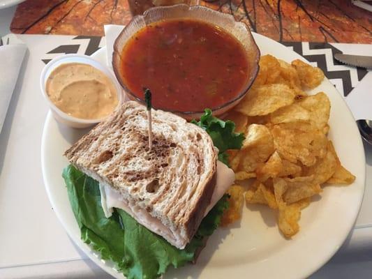 Half a sandwich with cucumber turkey and hummus, chips and tomato soup!