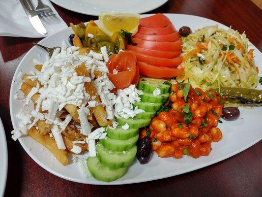 Side dish platter with feta fries, cabbage salad, Bulgarian bean side and shopska sides.