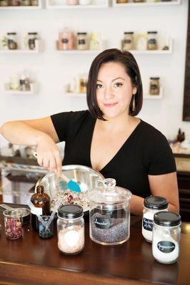 Owner of Urban Alchemy Lab mixing a combination of herbs to custom make a bath soak.