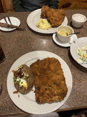 Baked Potato loaded and chicken fried steak with gray on the side.