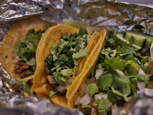 Ground beef tacos with onions and cilantro.