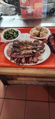 My plate with ribs, sausage, and brisket with ranch potatoes and green beans.