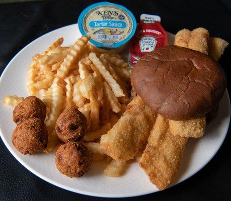 Fish sandwich  on rye with fries and hushpuppies.  Plated at home.