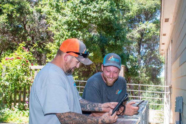 Friendly technicians  finishing a mini-split installation.