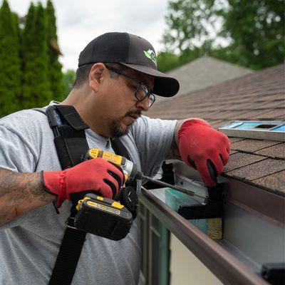 Contractor Installing Gutter System on Home