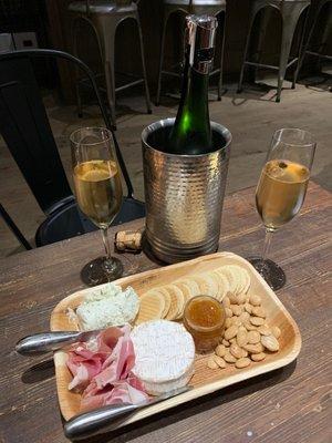 Champagne bottle and charcuterie board that we had to assemble ourselves.