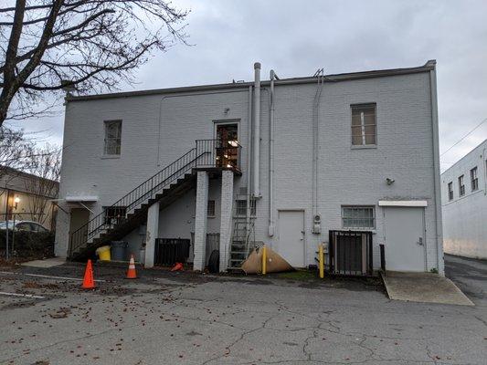 Outside. Entrance and free parking lot is in the back. Take the stairs up to the 2nd floor of the building.