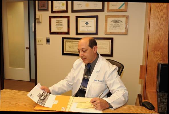 Dr. Maury Masliah designing a treatment plan at his desk.