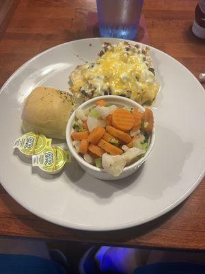 Loaded chicken breast with steamed vegetables and a roll