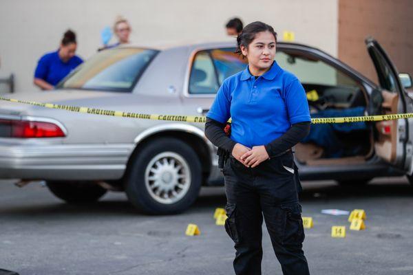 Criminal Justice student standing guard over mock crime scene.