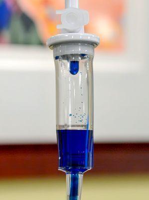 Methylene blue dripping in a an IV bag drip chamber.