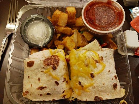 Closeup of my breakfast burrito with bacon inside. Also includes fried potatoes and salsa and sour cream. YUM!