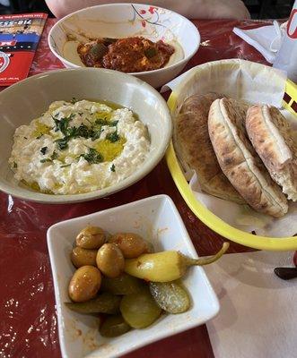 Shakshuka, Babaganush Salad, olives and pickles, pita bread.