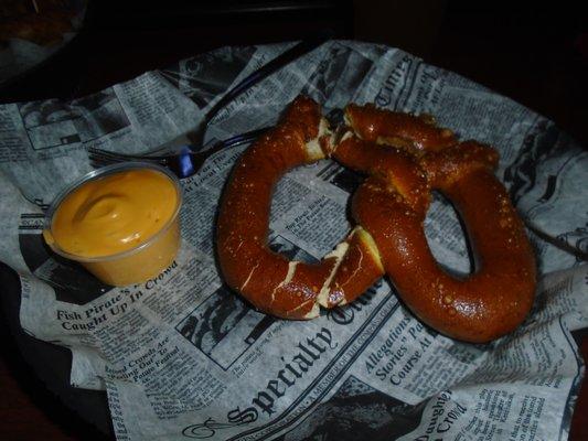 A warm giant pretzel with cheese sauce.