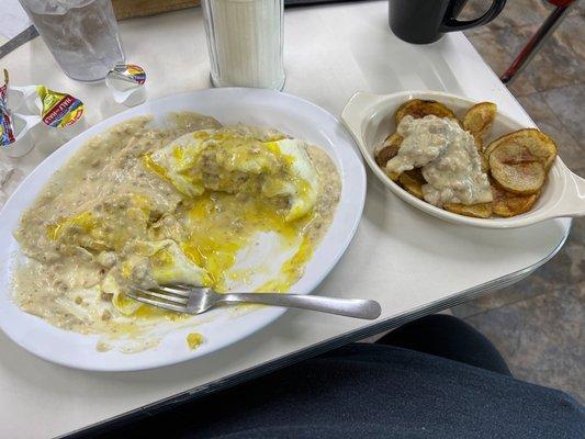 Biscuits & gravy with 2 eggs over easy on top with a side of home fries