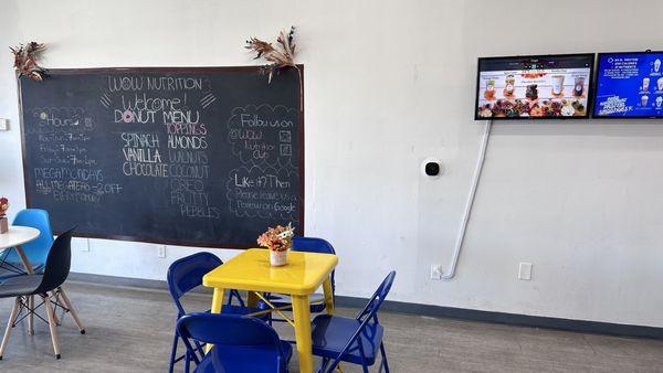 Menu board, screens where they have smoothie options and great tables to sit and enjoy your smoothie.