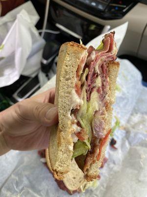 Pastrami sandwich with horseradish sauce and bacon on toasted rye