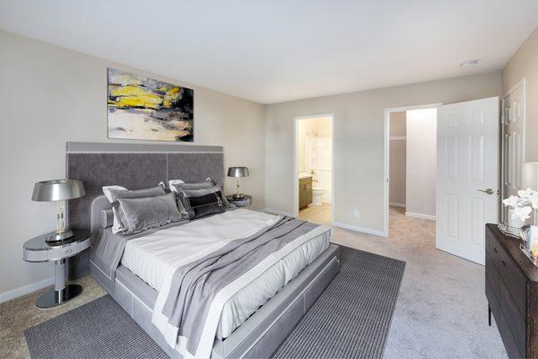 Bedroom with staged furniture and carpet.