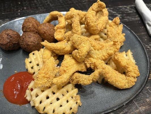 Catfish dinner with waffle fries and hush puppies