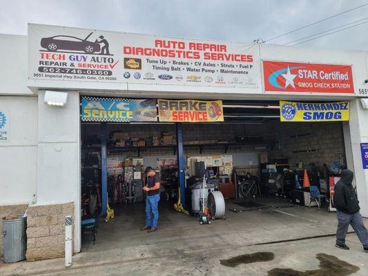 Front of shop, contact info, and a poster with the makes of cars they take care of