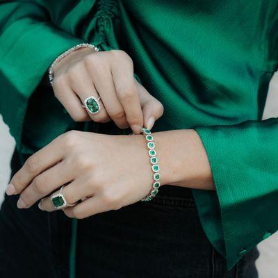 A woman wearing all emerald Jewelry