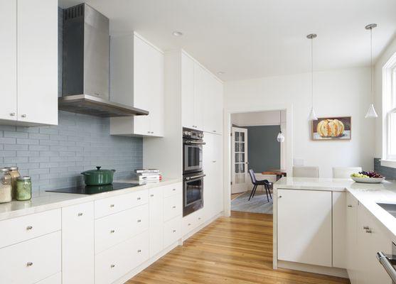 Gorgeous grey-green subway tiles warm up this client's nearly-all-white kitchen in San Francisco, and tone with the dining room wall paint.