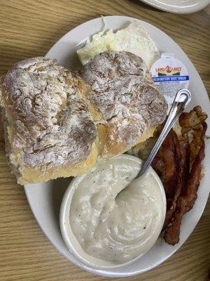 Two over medium eggs, four strips of bacon, shredded hash browns, two biscuits and gravy.