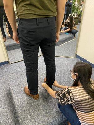 The owner taking measurements for a pants hemming.