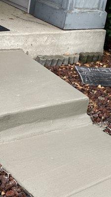 Jagged fracture between step and walk was skim coated rather than raising the sidewalk to the step.