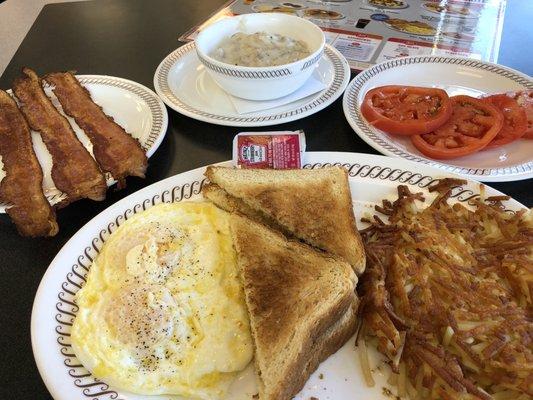 Two egg breakfast with bacon, gravy, and tomato