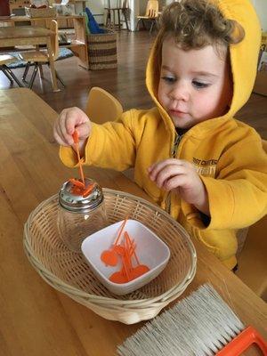 Pre-primary Children concentrating on a sugar shaker piece of work which improves fine motor skills