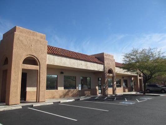 Main entrance under the tower and parking lot.